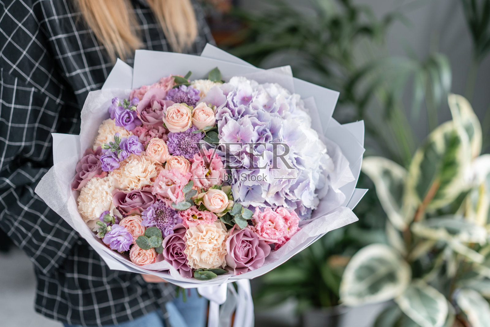 女人手里拿着一束美丽的混合鲜花。花店概念。英俊的新鲜的花束。花交付。红色和粉红色。照片摄影图片