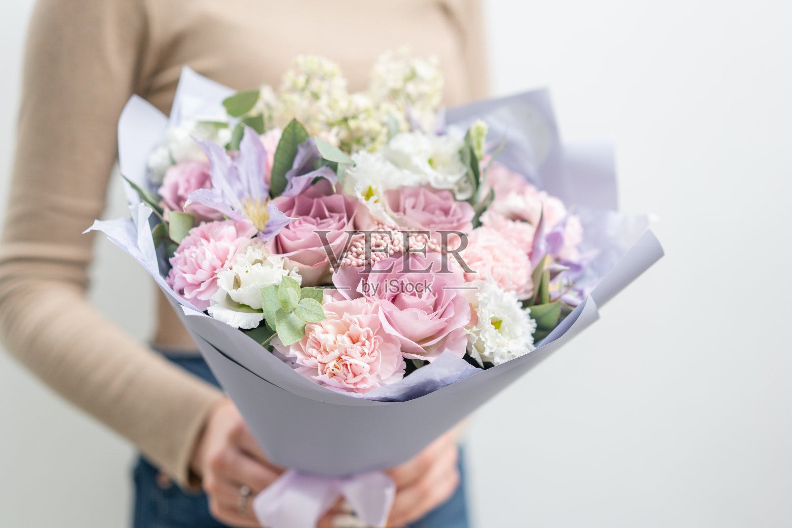 女人手里拿着一束美丽的混合鲜花。花店花匠的工作。精致柔和的颜色。新鲜切花。粉红色和淡紫色照片摄影图片