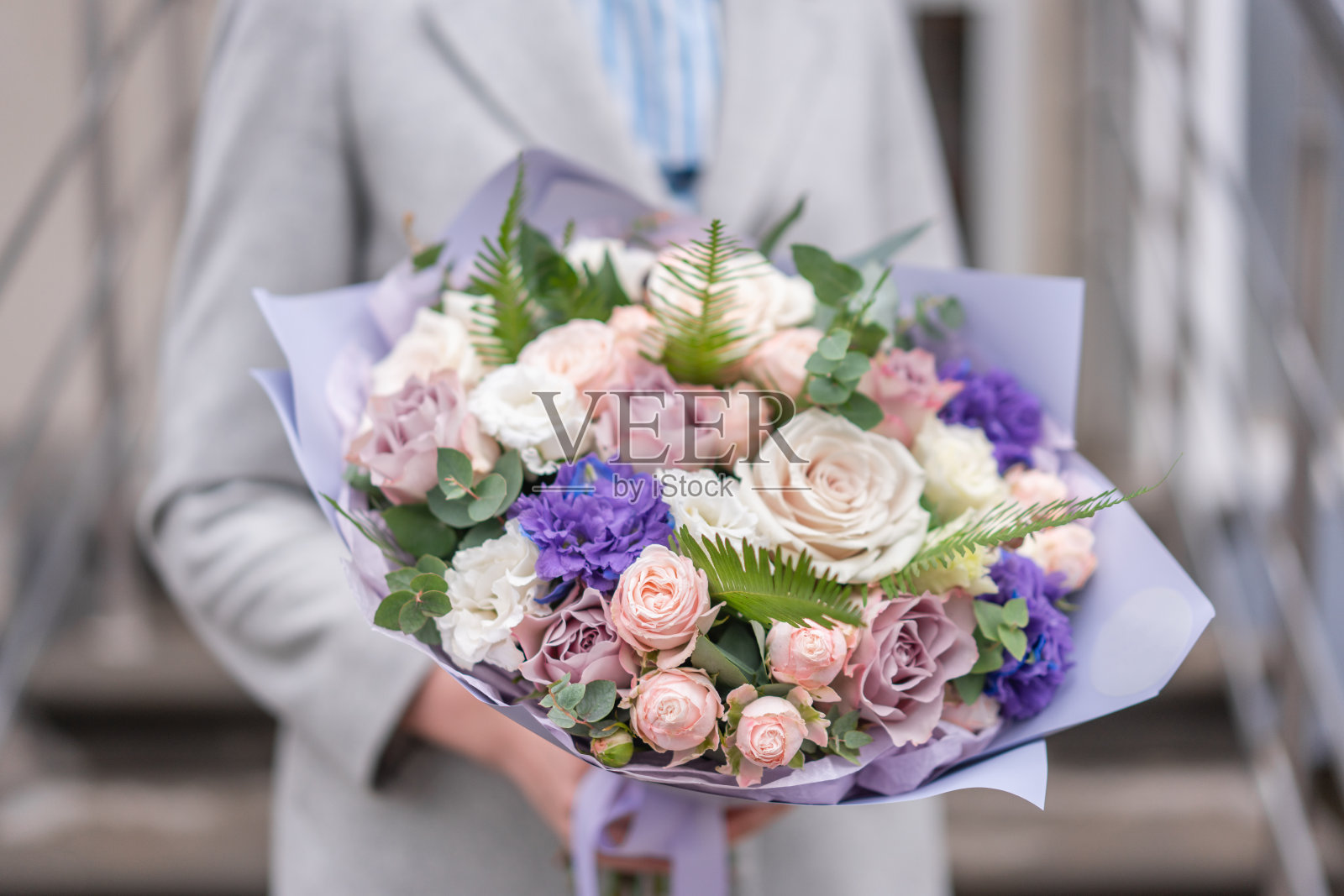 女人手里拿着一束混合鲜花。粉红色和白色。花店花匠的工作。精致柔和的颜色。新鲜切花。照片摄影图片