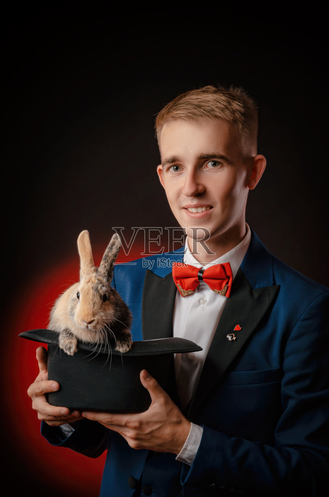 一个年轻的魔术师拿着一顶有兔子的帽子照片摄影图片