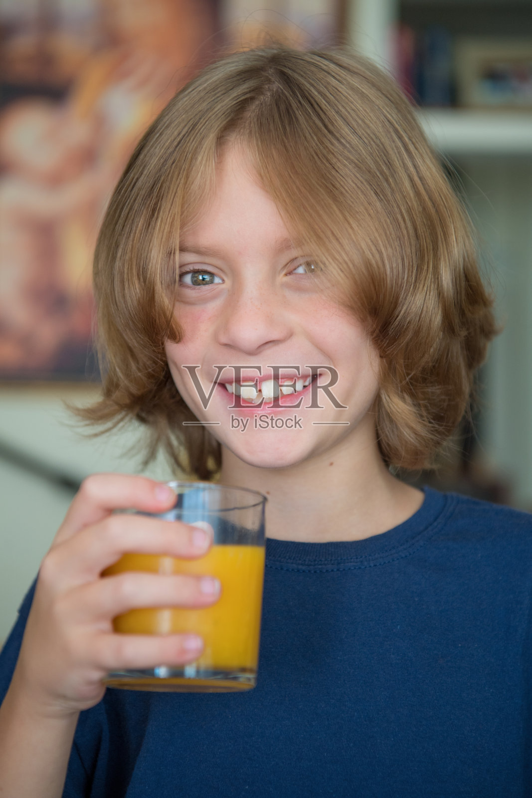 9岁的小男孩拿着一杯橙汁照片摄影图片