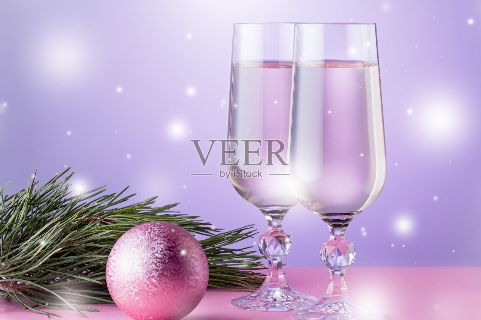 圣诞卡与两杯香槟，圣诞饰品，冷杉树枝在粉红色的颜色。本空间照片摄影图片
