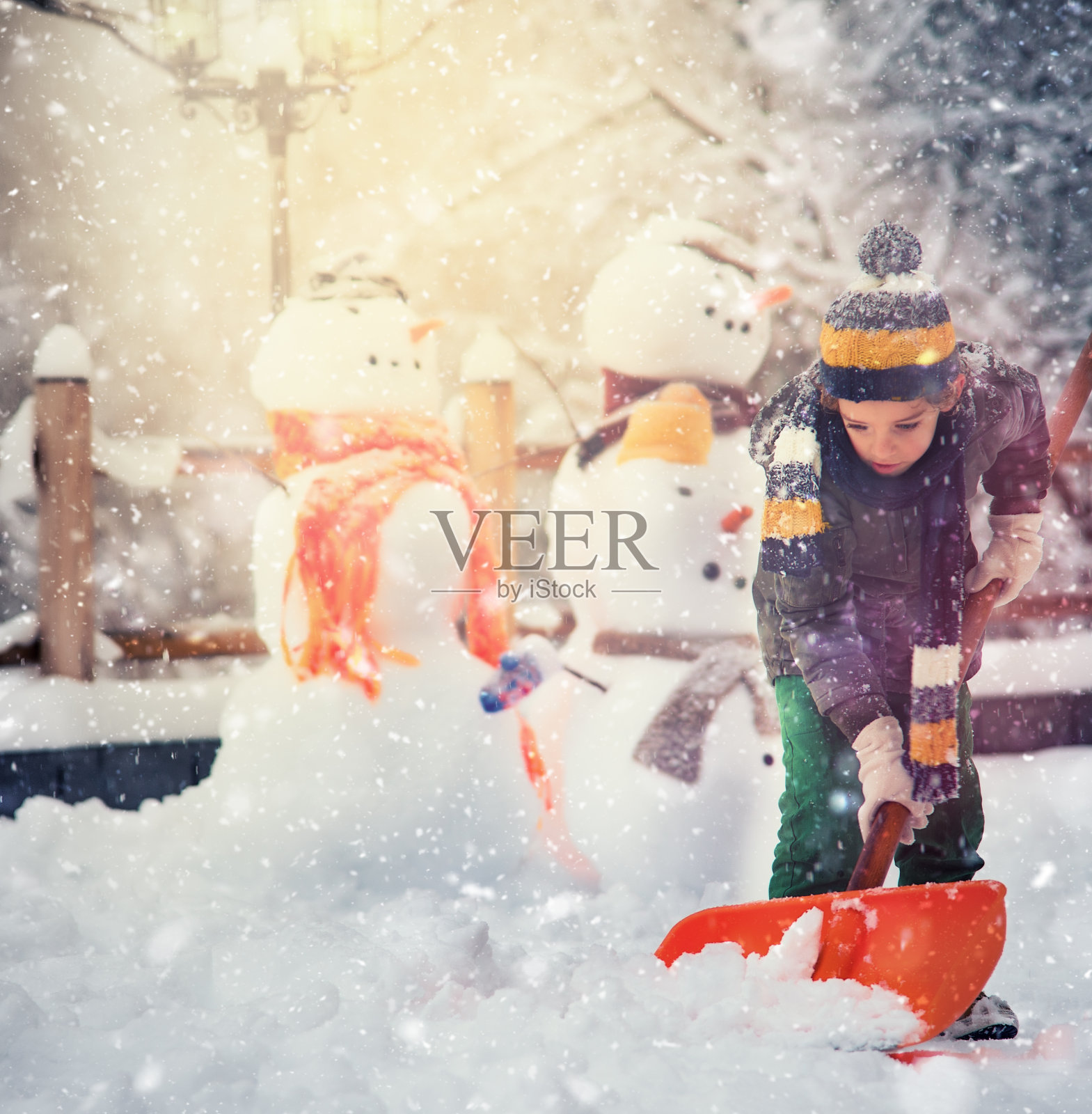 小男孩用铁锹清理雪道照片摄影图片