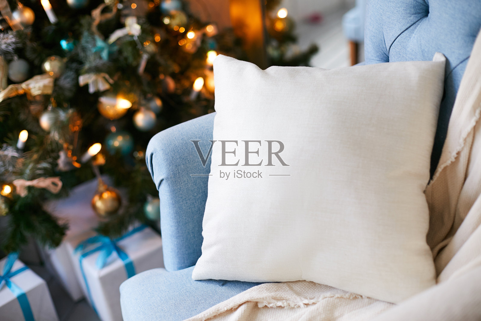 圣诞树旁有一个枕头的蓝色软扶手椅照片摄影图片
