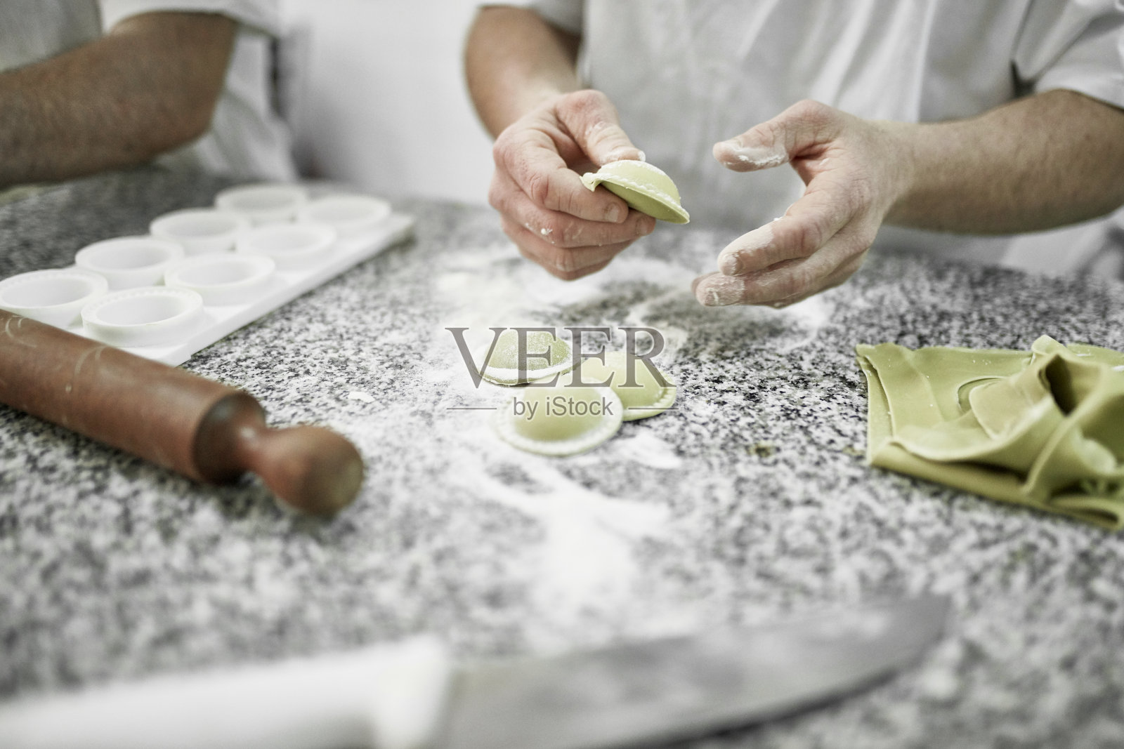 一名男性工人正在意大利面食厂制作菠菜馄饨照片摄影图片