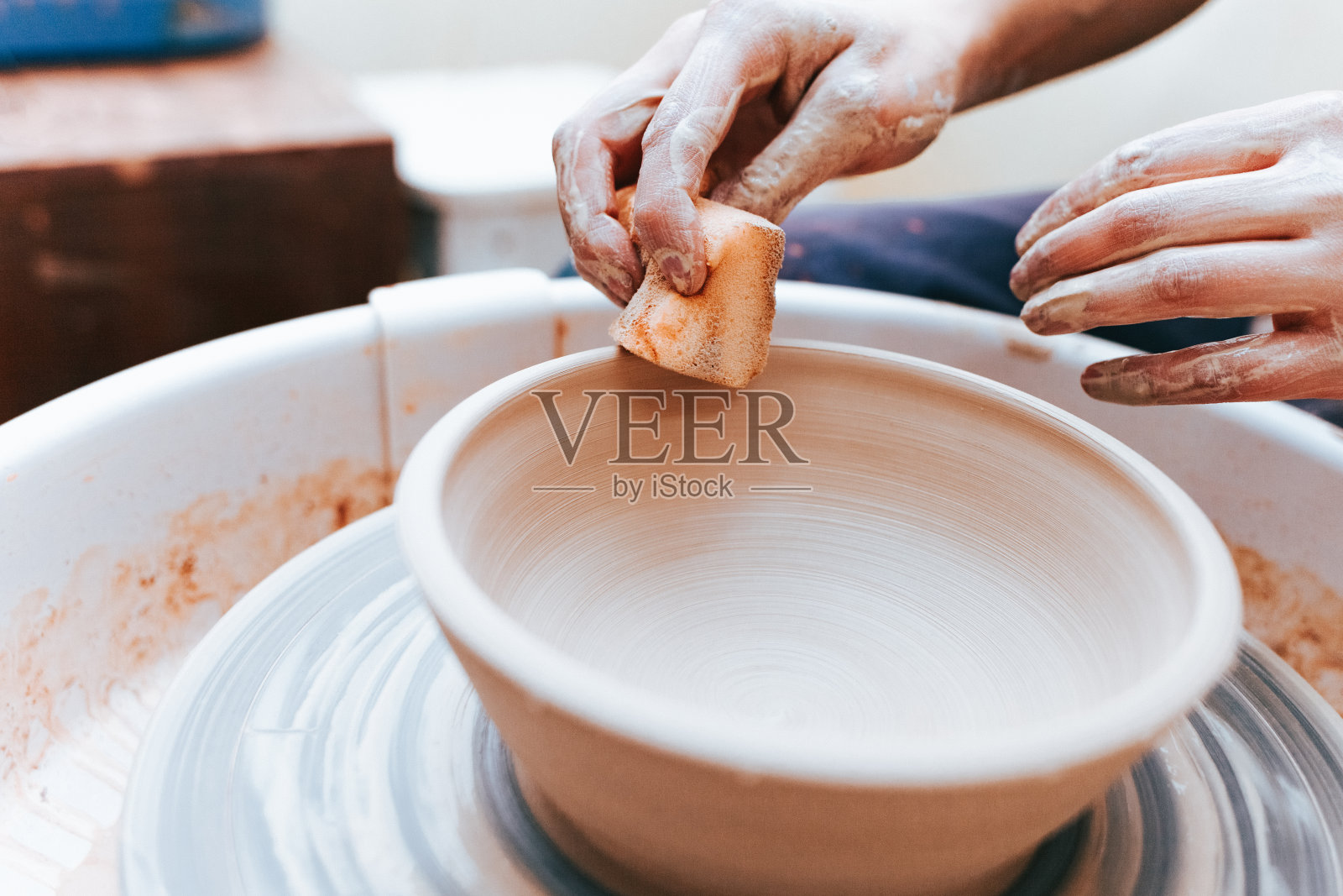 创造和形成白色粘土陶瓷板的过程。专业陶工是从事陶片造型的陶工。波特在一个车间工作照片摄影图片