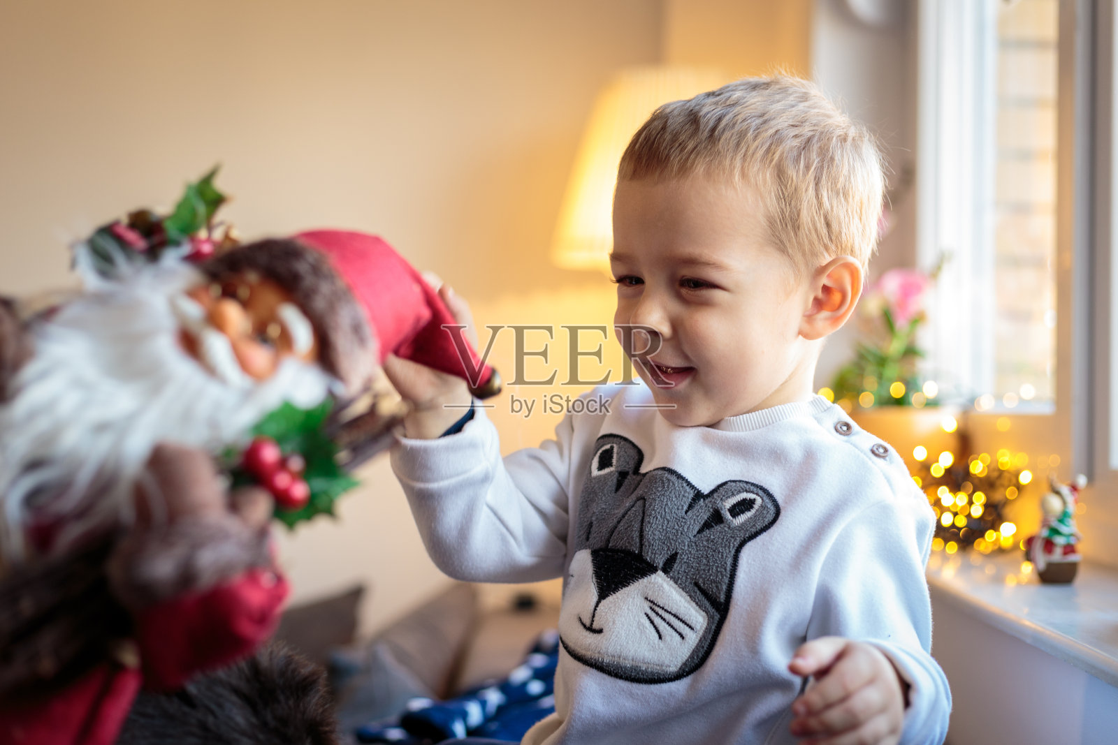 可爱的小男孩在玩圣诞老人娃娃照片摄影图片