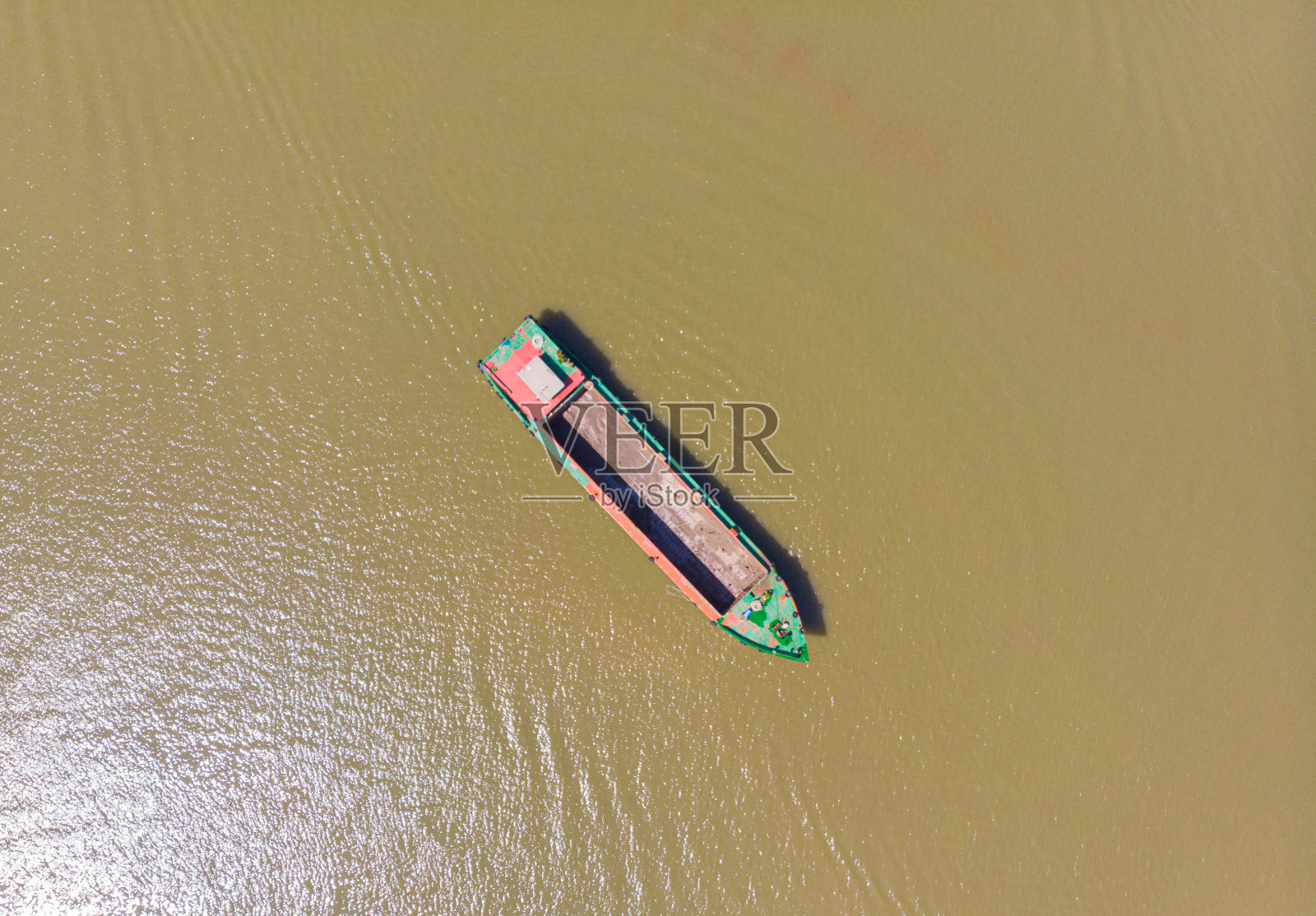 一艘货轮漂浮在越南南部的湄公河三角洲地区。直上直下的一艘船在棕色的浑水上。照片摄影图片