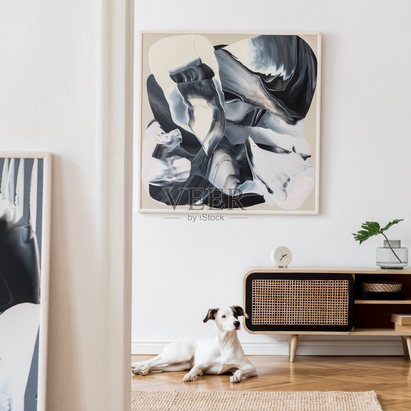 设计scandi家居室内的客厅与木马桶，黑藤蒲垫，植物和优雅的配件。时尚家居装饰。模仿抽象画。狗躺在地板上。模板。照片摄影图片