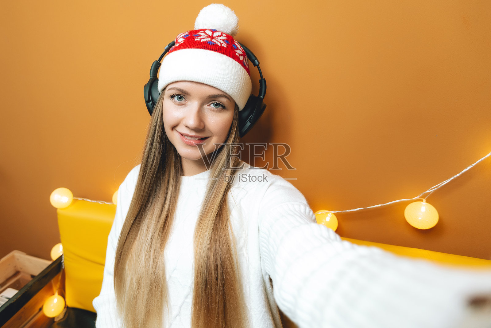 戴着圣诞帽戴着耳机自拍的好女孩照片摄影图片