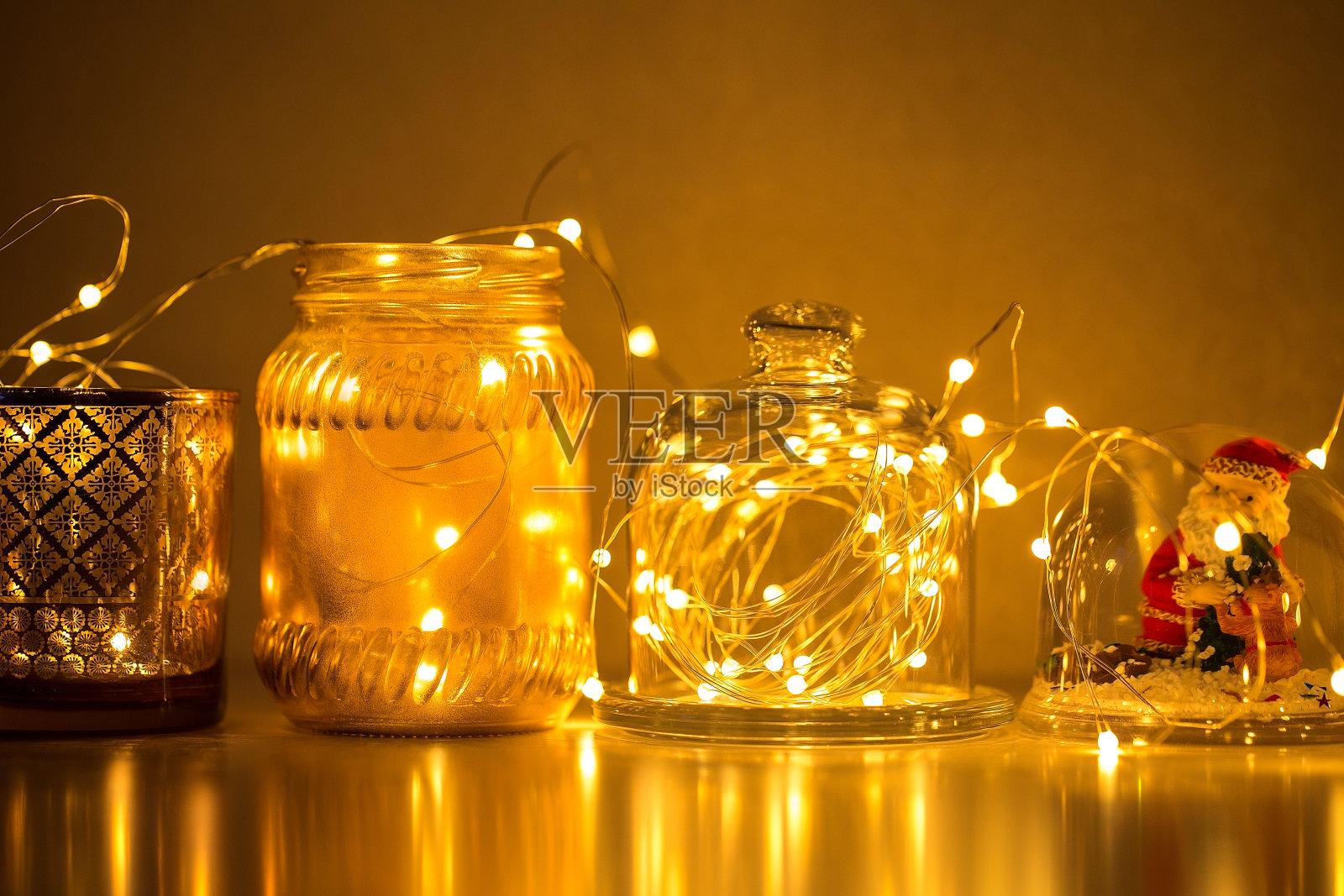 花环和装饰创造一个舒适的家，金丝灯，烛台，一个花瓶，一个雪玻璃球和其他装饰品照明。照片摄影图片