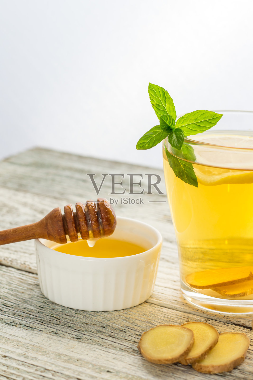 姜茶，柠檬薄荷和蜂蜜在白色的木制背景。热健康冬饮照片摄影图片