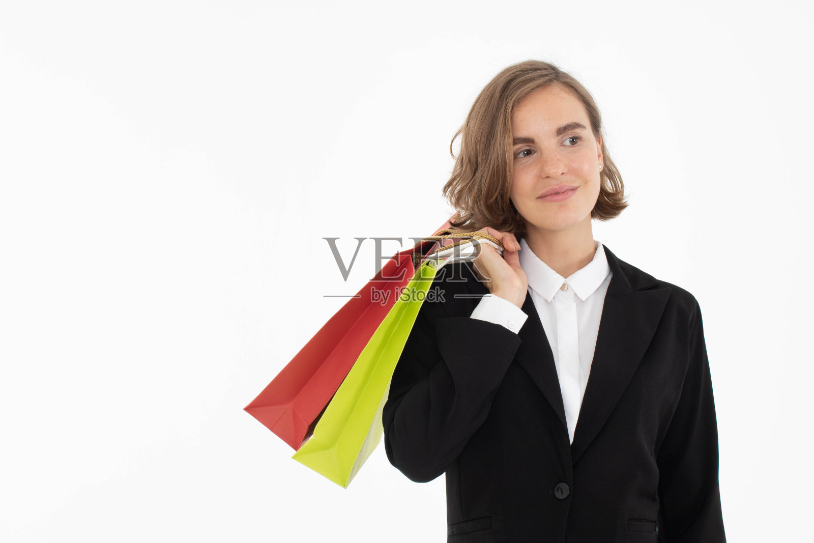 年轻的商业妇女的肖像拿着购物袋在白色孤立的背景。照片摄影图片