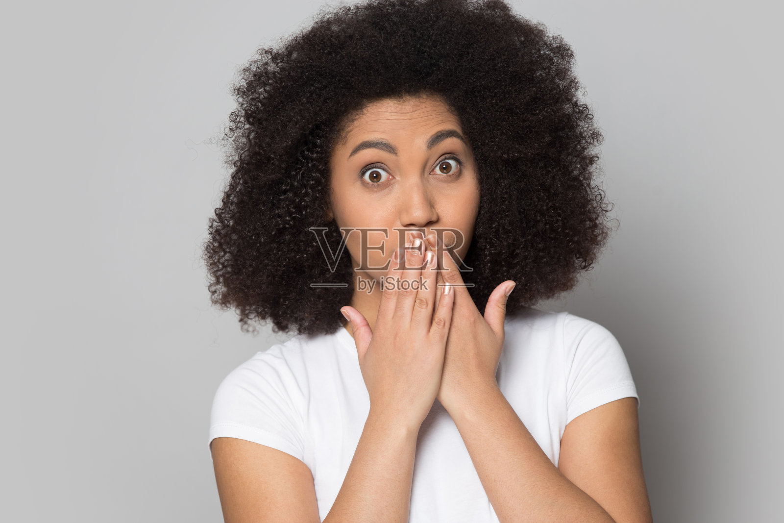 惊讶的千禧一代非洲裔美国女士用手捂着嘴。照片摄影图片
