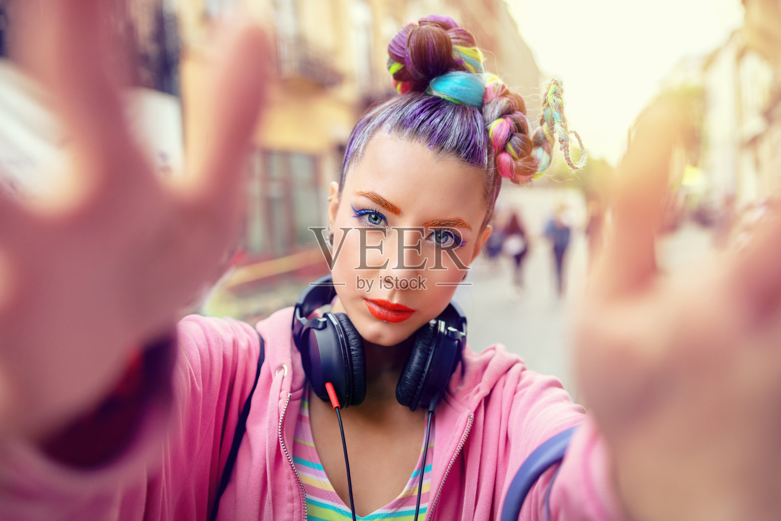 好玩酷时髦的年轻女孩戴着耳机和疯狂的头发在街上自拍照片摄影图片