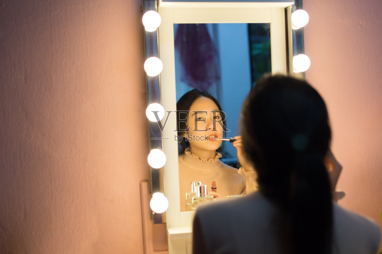 可爱的亚洲女人在时尚的镜子前用灯泡化妆照片摄影图片