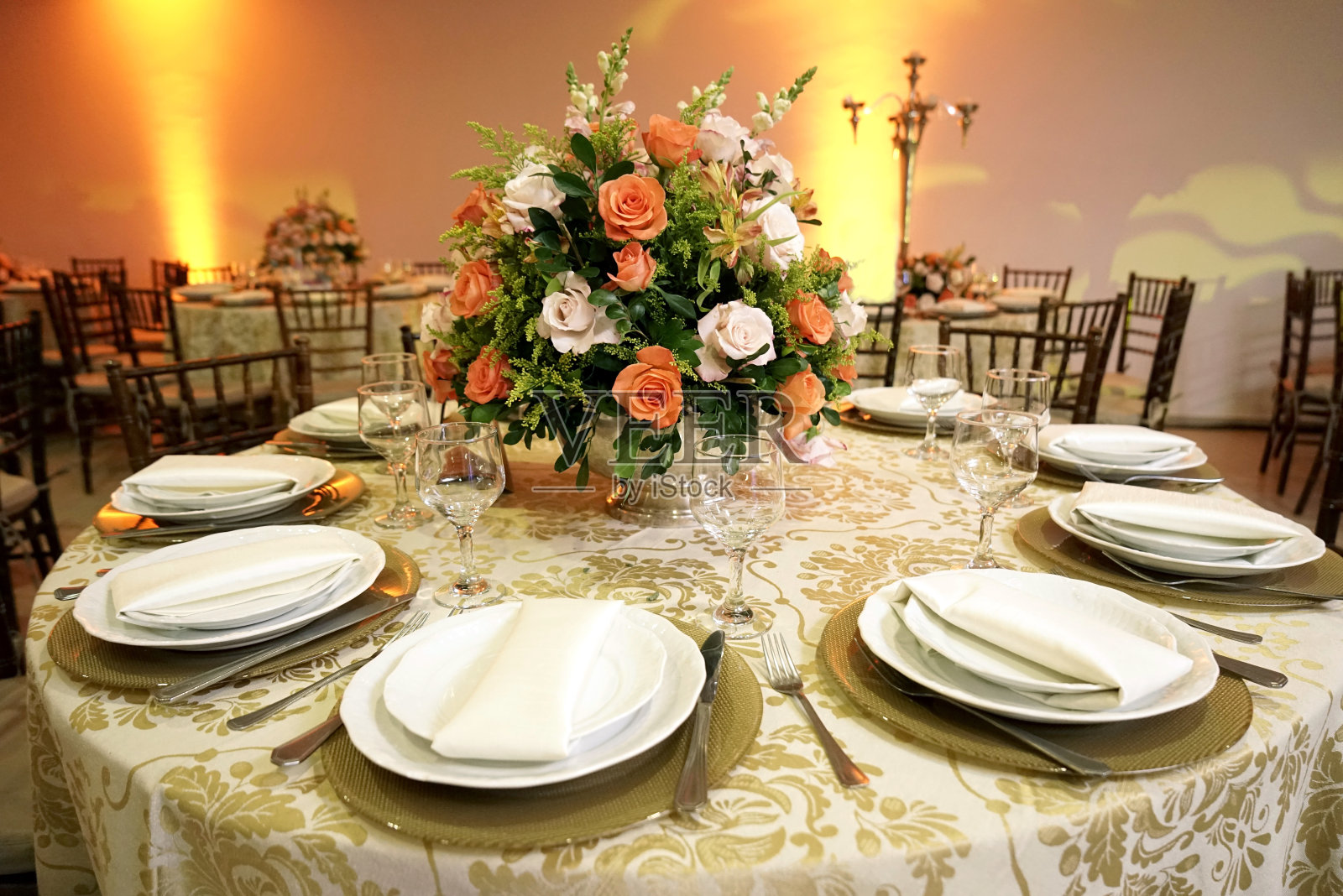 桌子设置杯，盘子，餐巾和食物，花卉插花在中心与模糊的背景。照片摄影图片