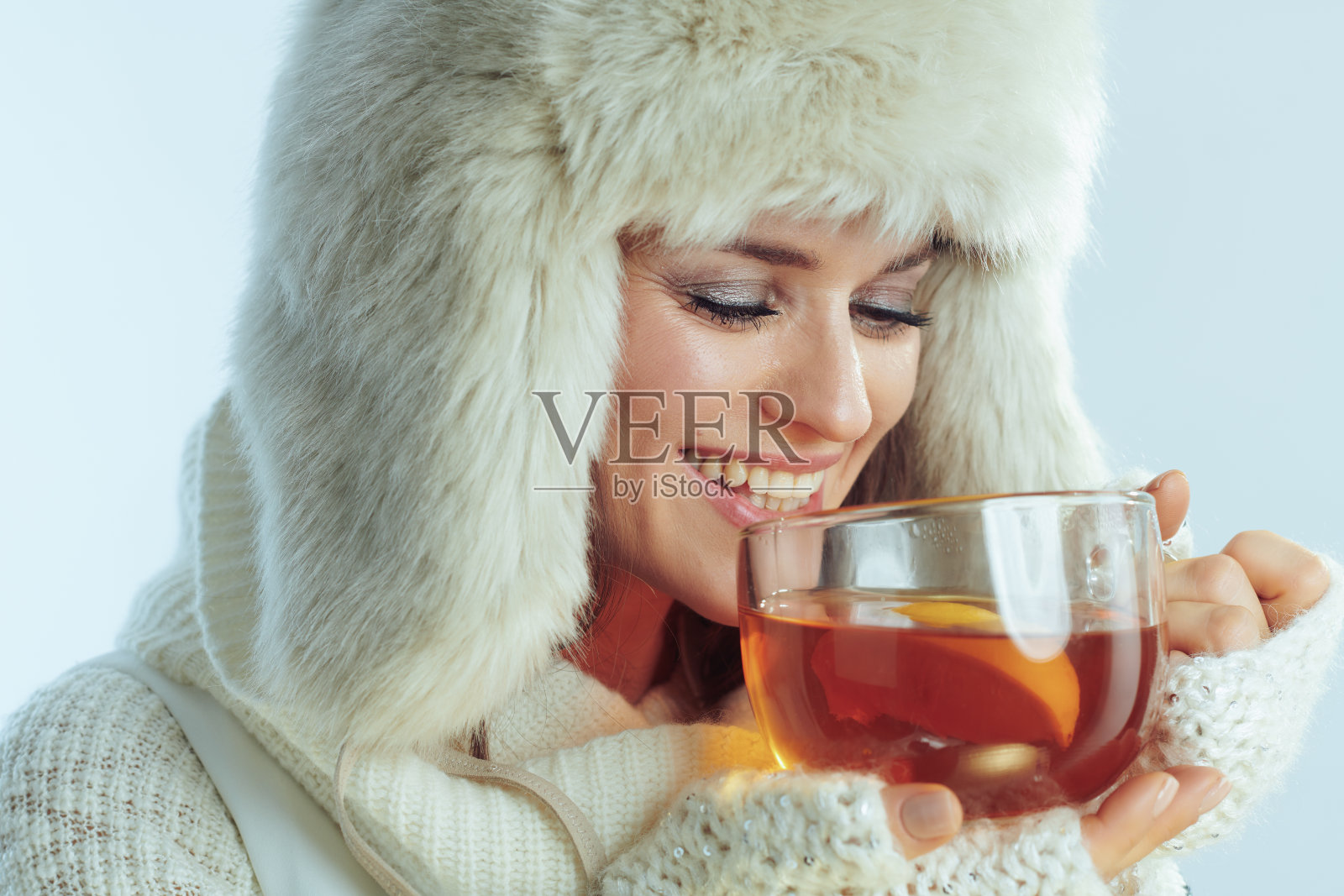 快乐的女人喝着柠檬和蜂蜜的热茶照片摄影图片