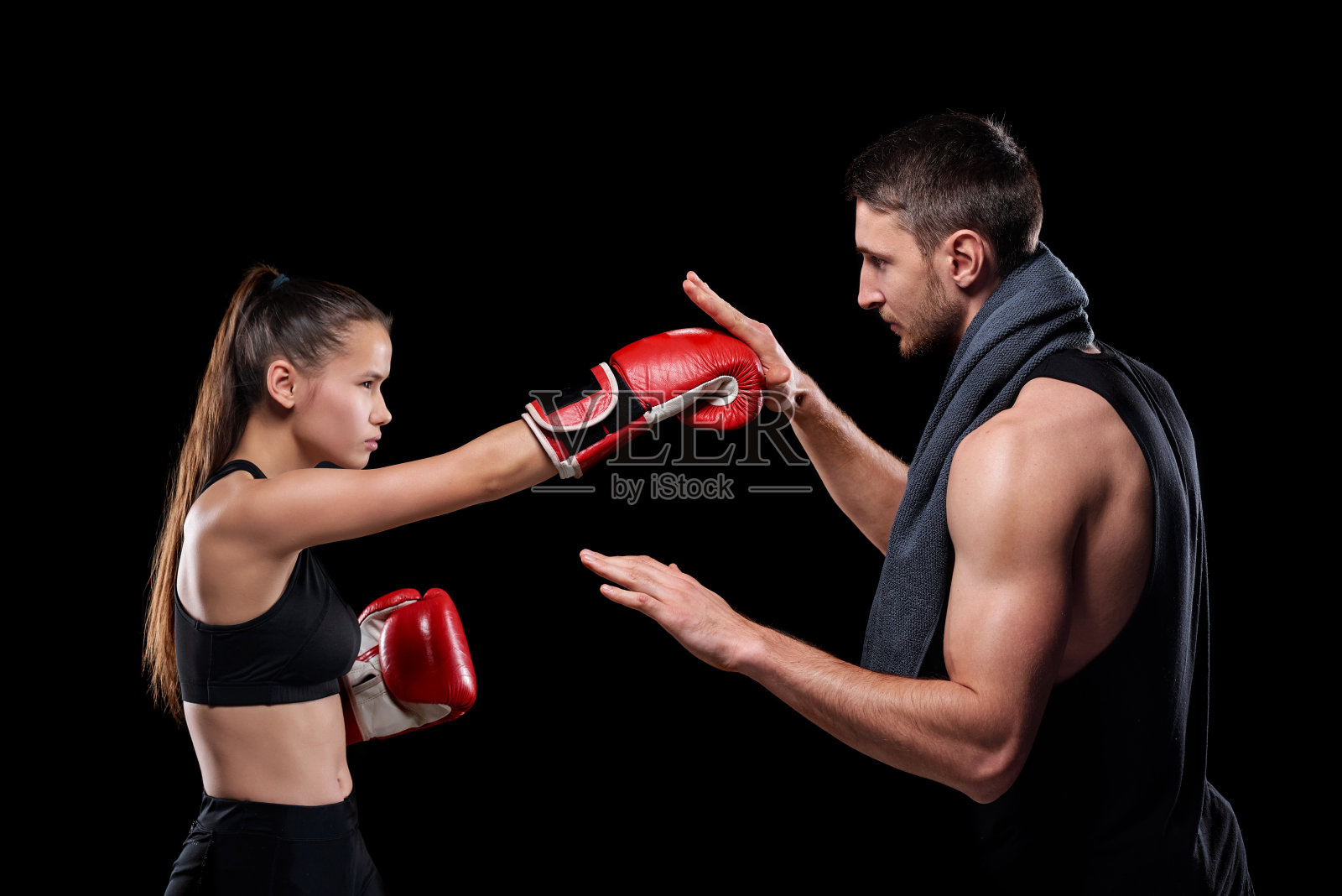 年轻女运动员在运动服和拳击手套与教练锻炼照片摄影图片