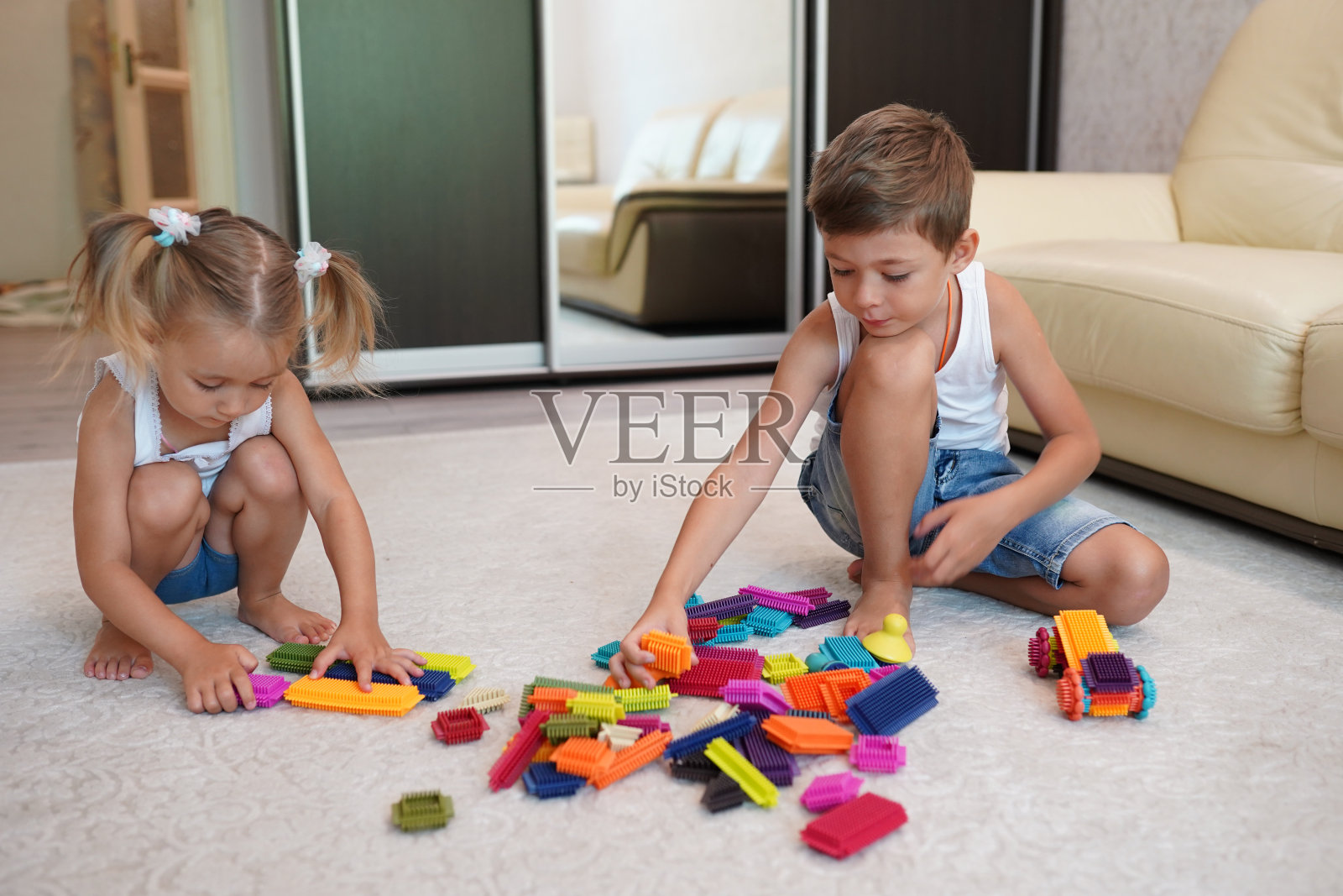 两个孩子在家里的地板上玩积木照片摄影图片