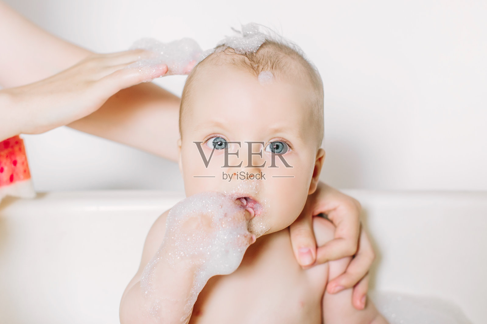 快乐的笑宝宝洗澡玩泡沫泡沫。浴缸里的小孩。婴儿洗浴。卫生和幼儿护理。照片摄影图片