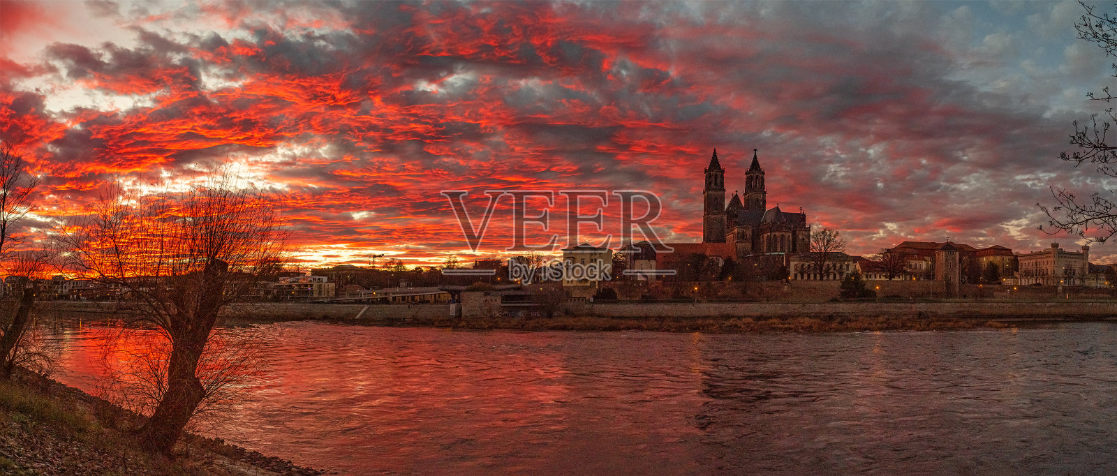 马格德堡大教堂前美丽的血色日落全景，市中心和易北河，马格德堡，德国，冬季，红色多云的天空照片摄影图片