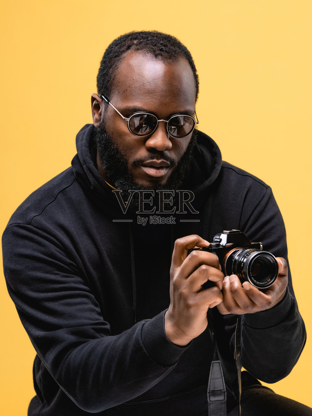 肖像胡子非洲裔美国专业摄影师与眼镜在工作室。照片摄影图片