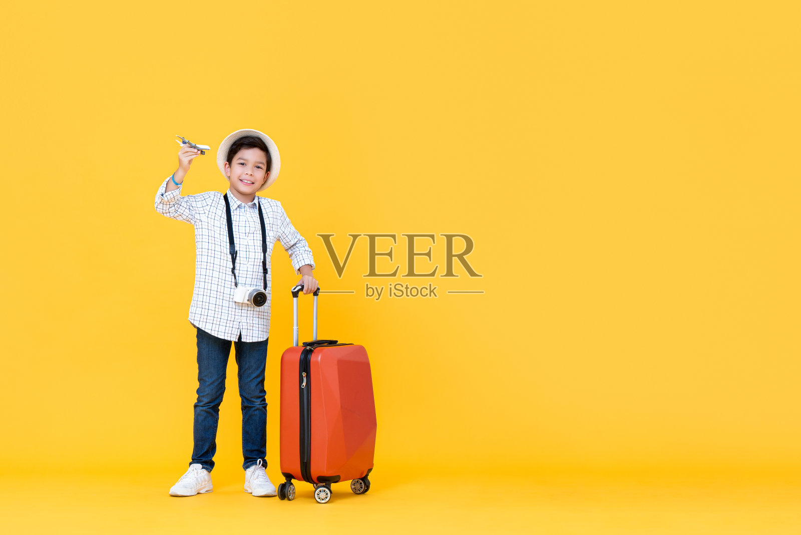 微笑的亚洲男孩去度假持有玩具飞机照片摄影图片