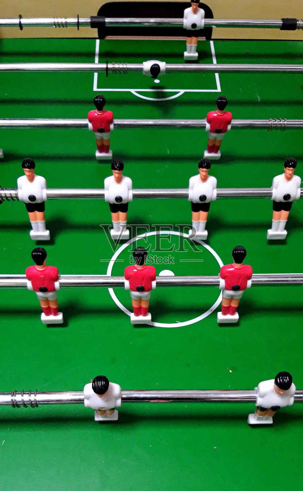桌上足球红白塑料球员排成一排进行比赛照片摄影图片