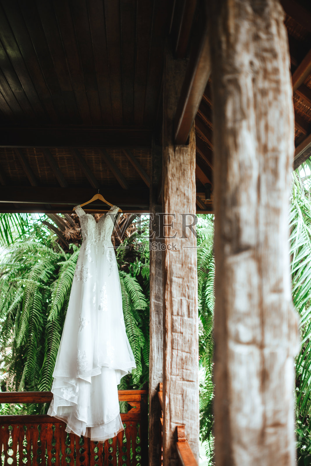 白色的婚纱挂在木制的乡村房子的阳台上照片摄影图片