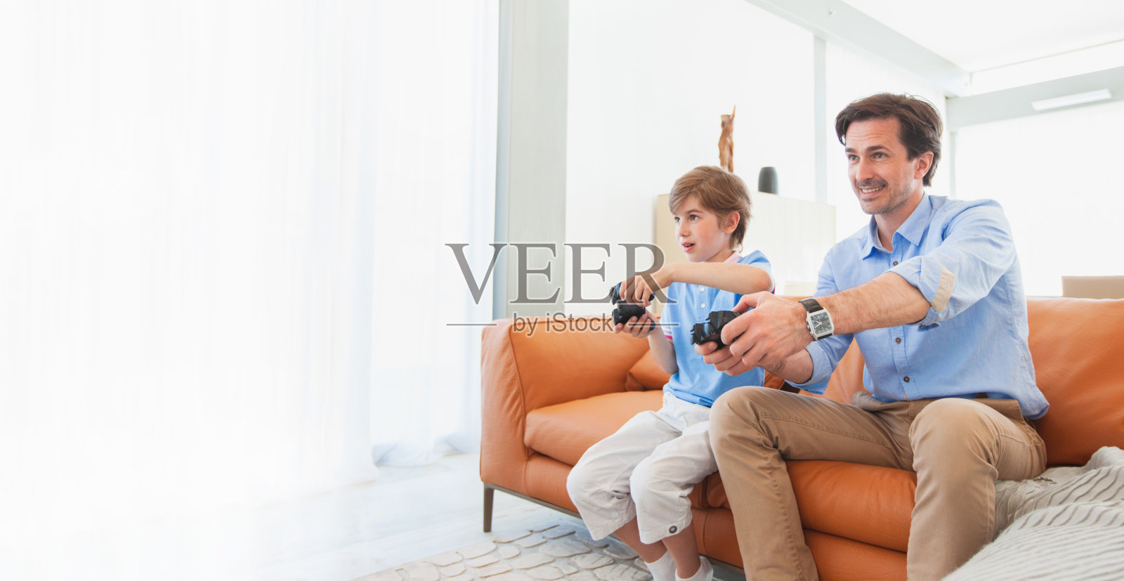 父亲和儿子玩电子游戏照片摄影图片