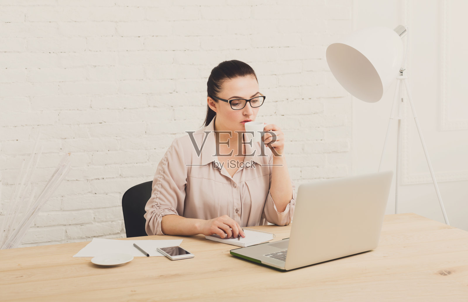 中年商界女性在办公室喝咖啡照片摄影图片