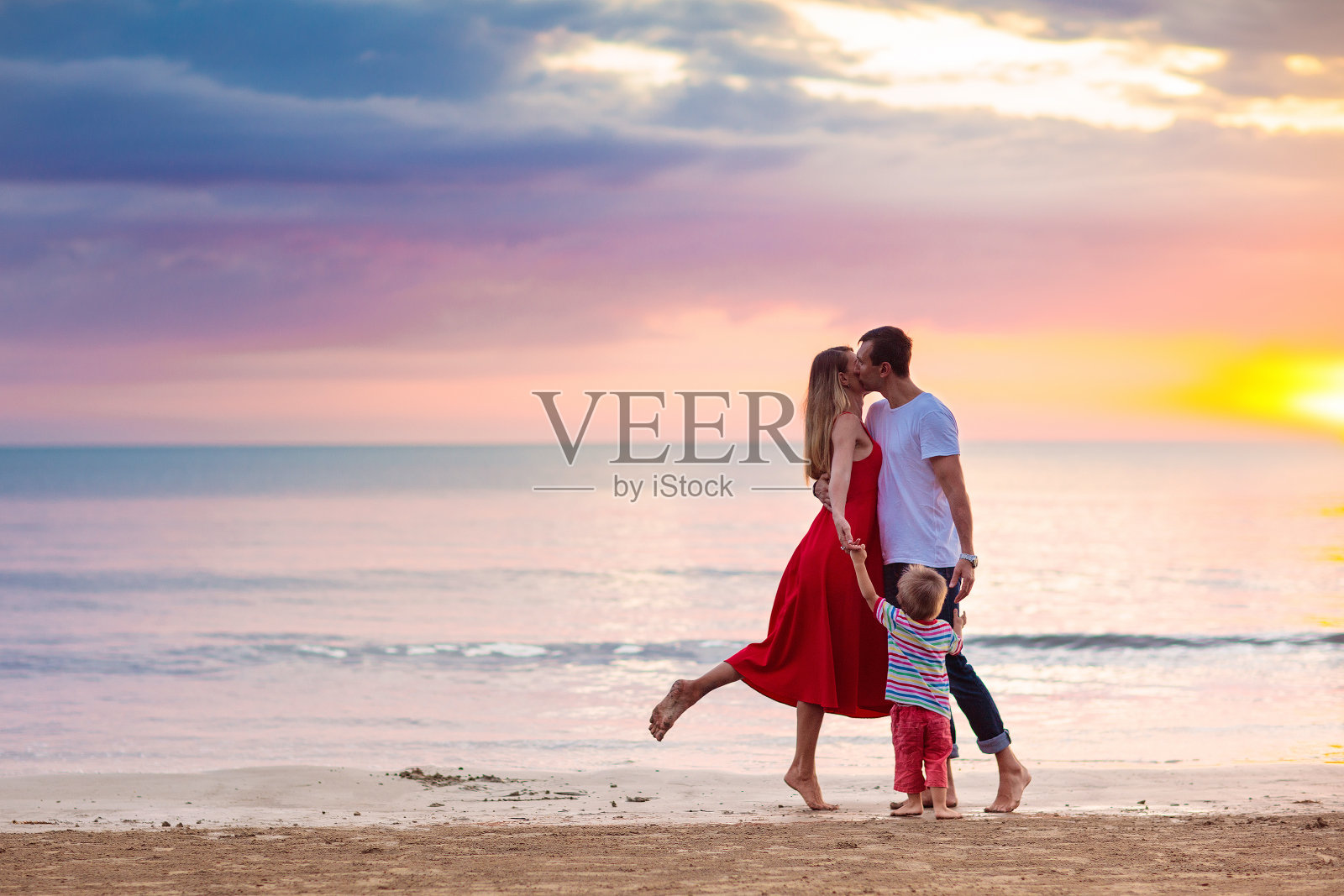 一家人带着孩子在热带海滩上。海上度假。照片摄影图片