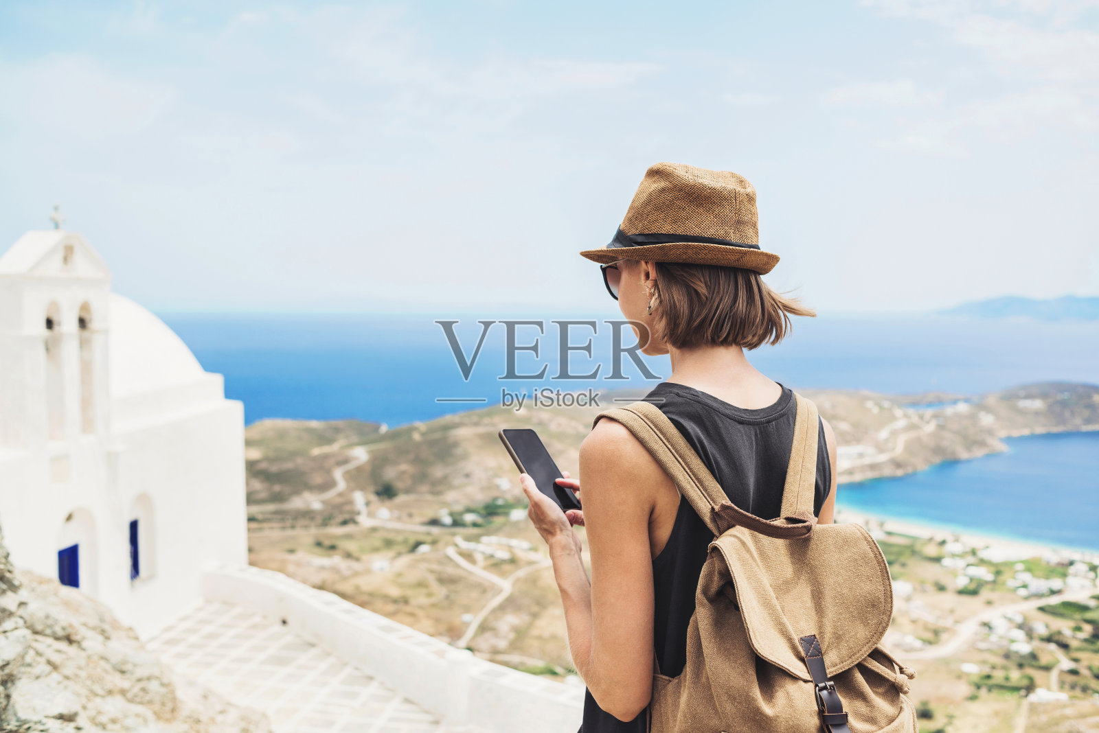 在希腊度假时用智能手机的女人照片摄影图片