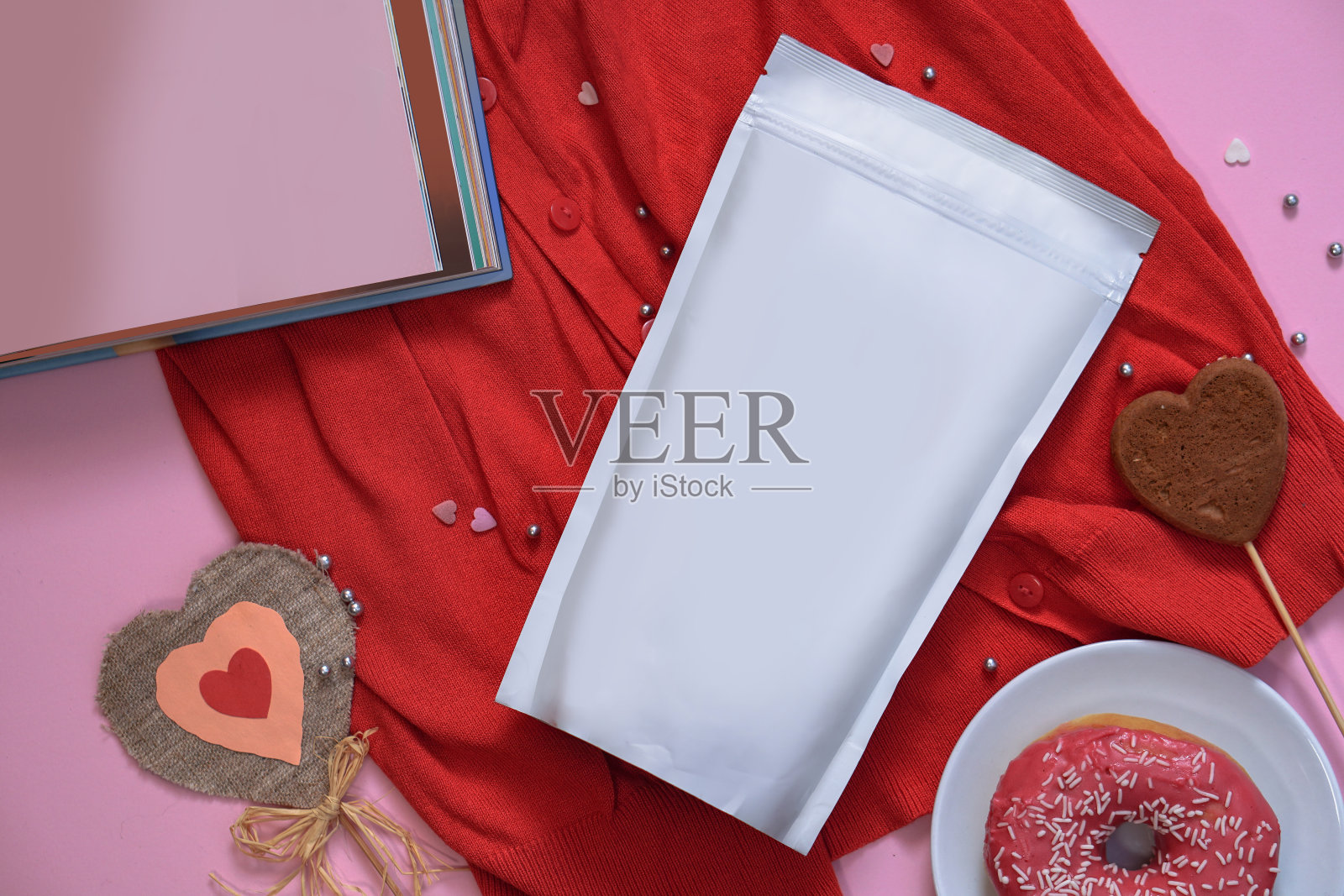 纸包装模板上的浪漫元素和甜甜圈的背景。动作捕捉品牌你的产品包装上。设计素材照片照片摄影图片