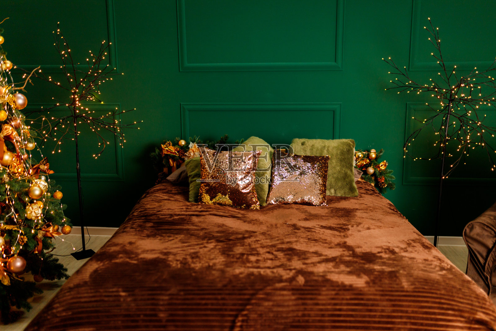 绿色的墙上挂着圣诞装饰的床照片摄影图片