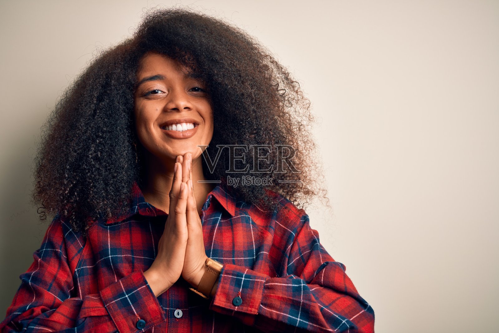 年轻美丽的非洲裔美国妇女穿着休闲衬衫在孤立的背景祈祷双手在一起请求原谅自信的微笑。照片摄影图片