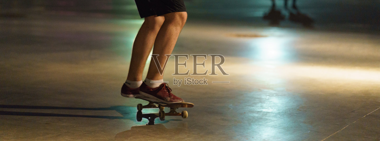 滑板者的腿和滑板的形象。照片摄影图片