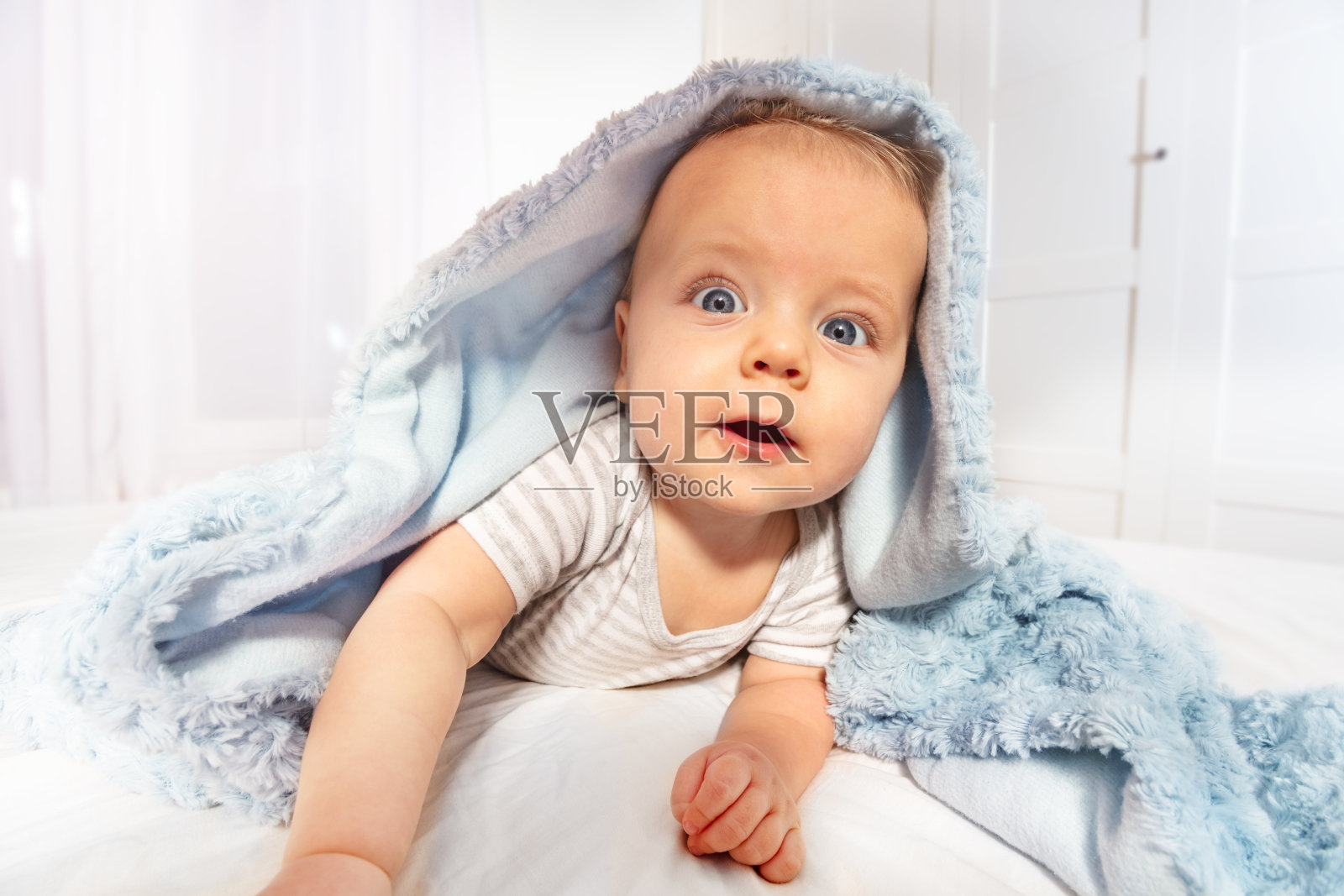 宝宝爬出毛巾，脸上露出惊喜的表情照片摄影图片