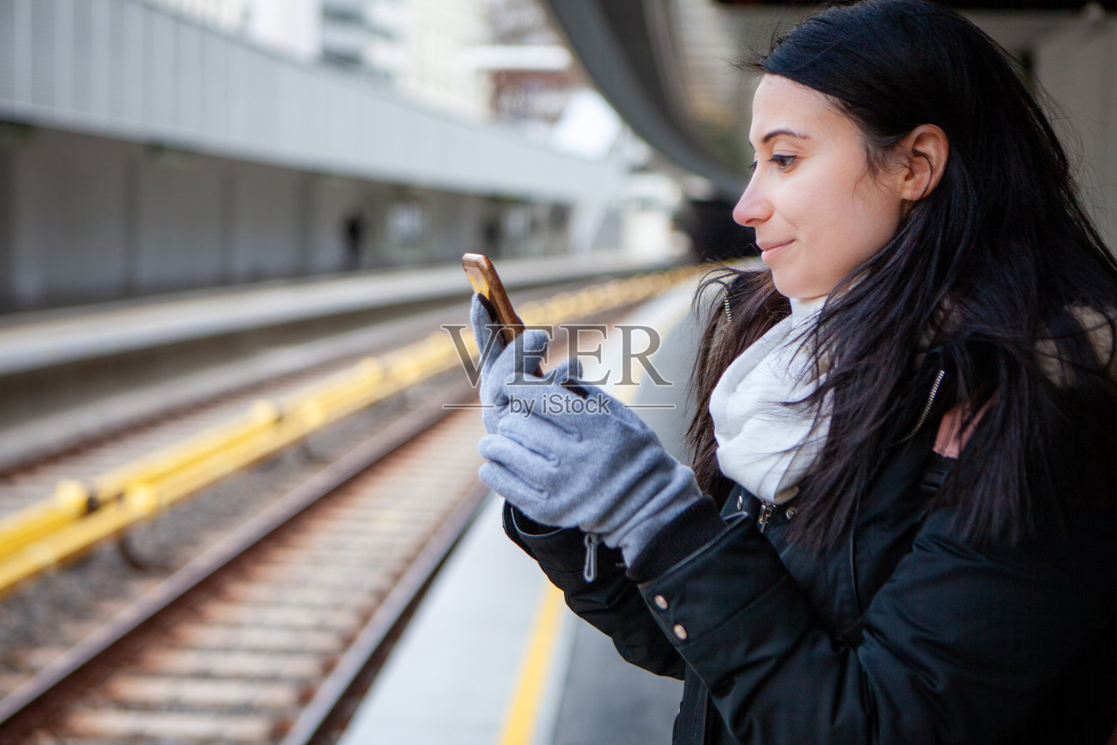 年轻女子在地铁站用手机储存照片照片摄影图片