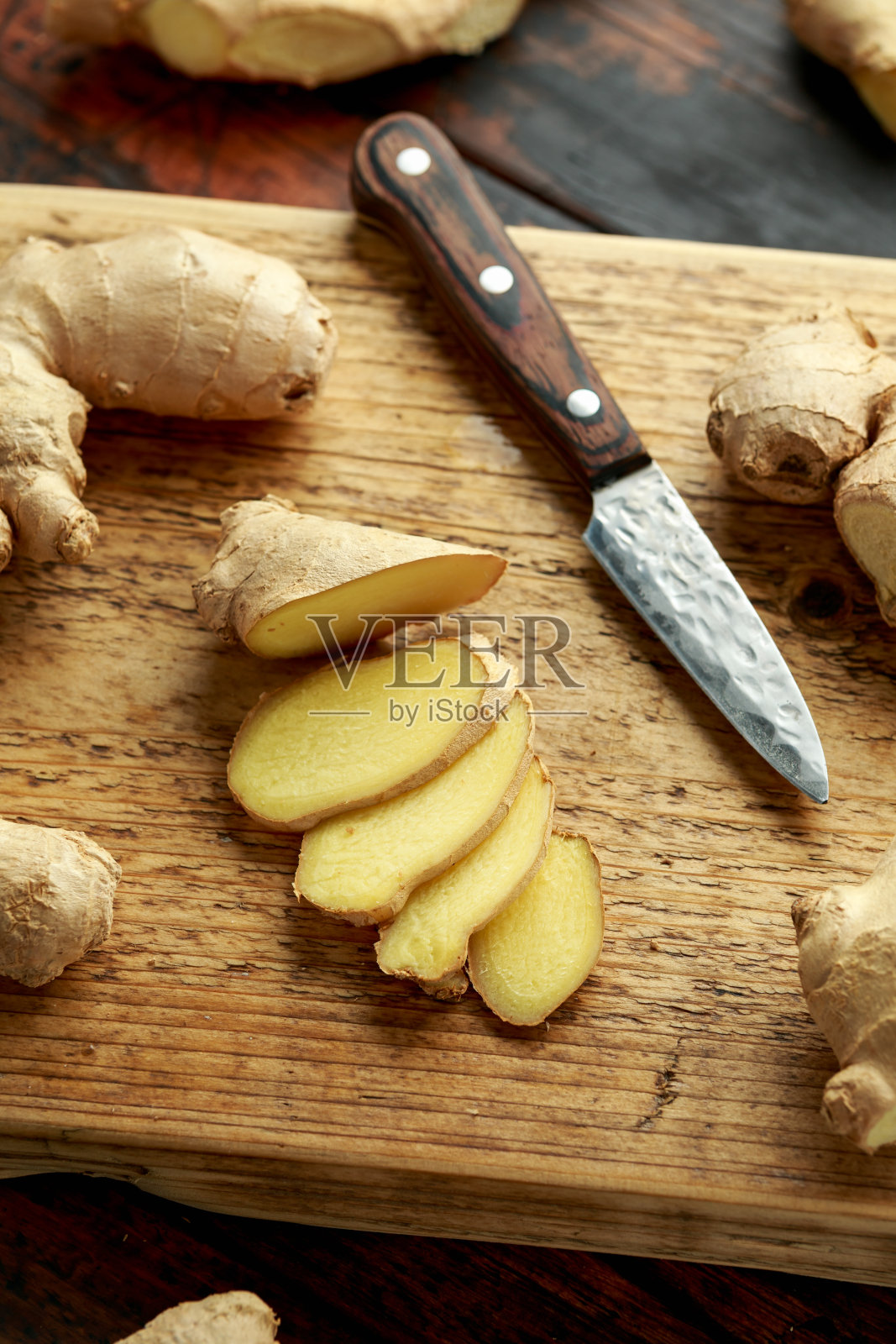 新鲜的姜片放在木砧板上。健康的食物照片摄影图片