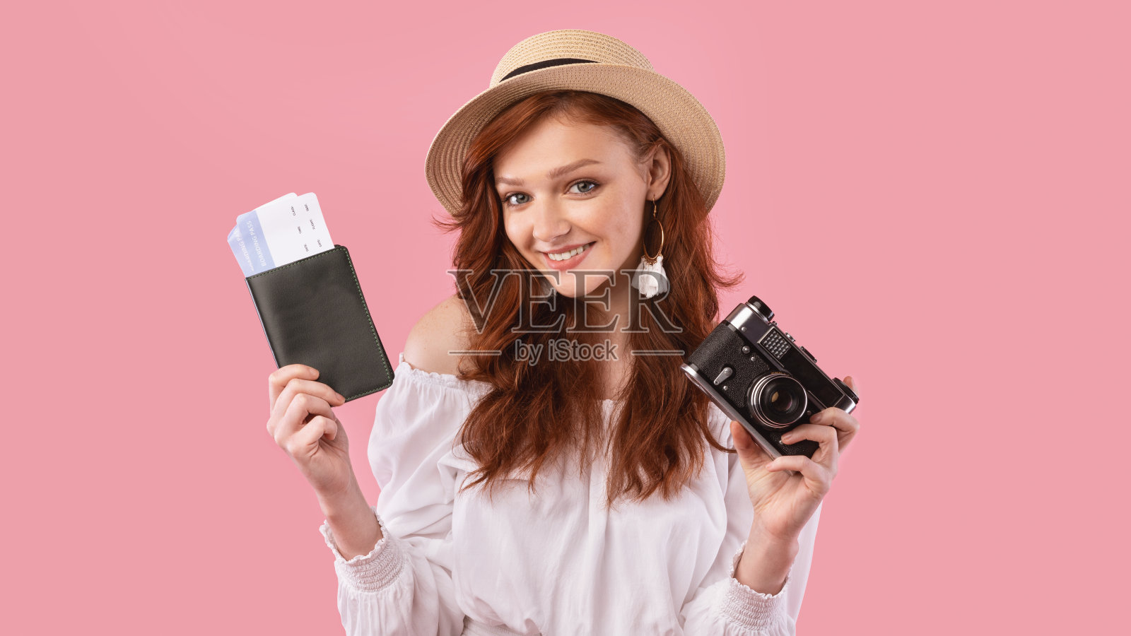可爱的旅行者女孩拿着票和相机在粉红色的背景照片摄影图片
