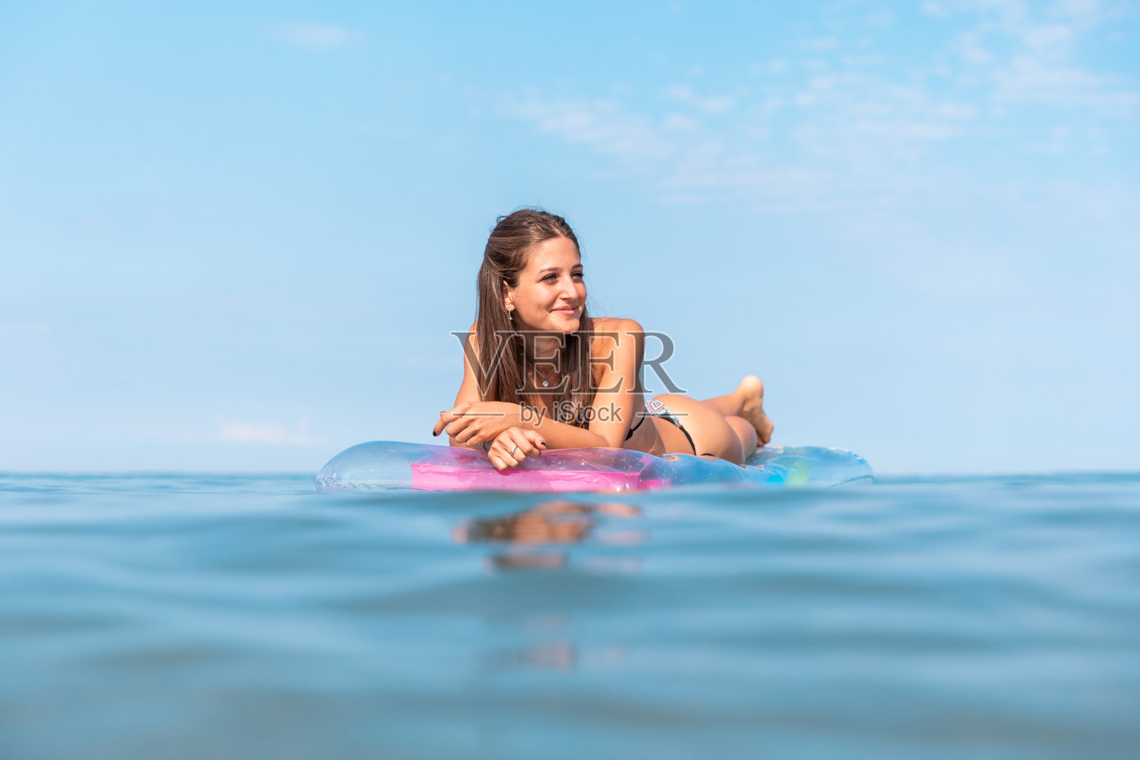 美丽的女孩在海边的充气床垫上休息照片摄影图片
