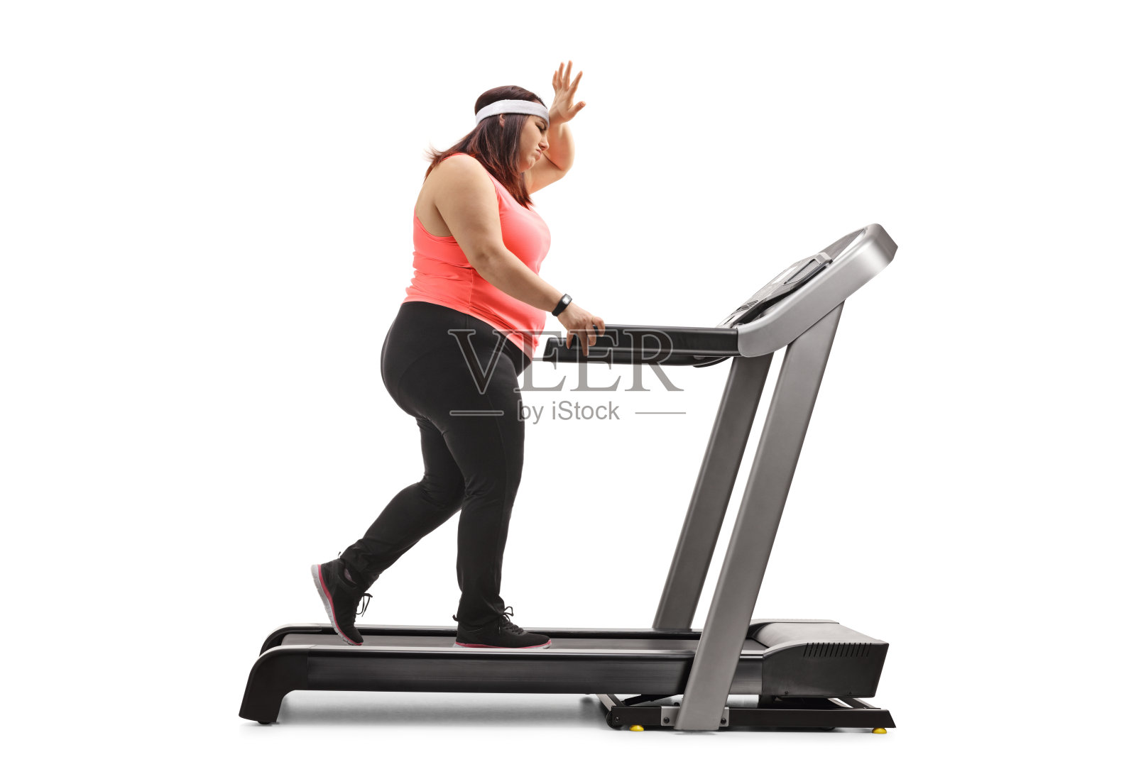 在跑步机上锻炼的超重女性，手捧额头照片摄影图片