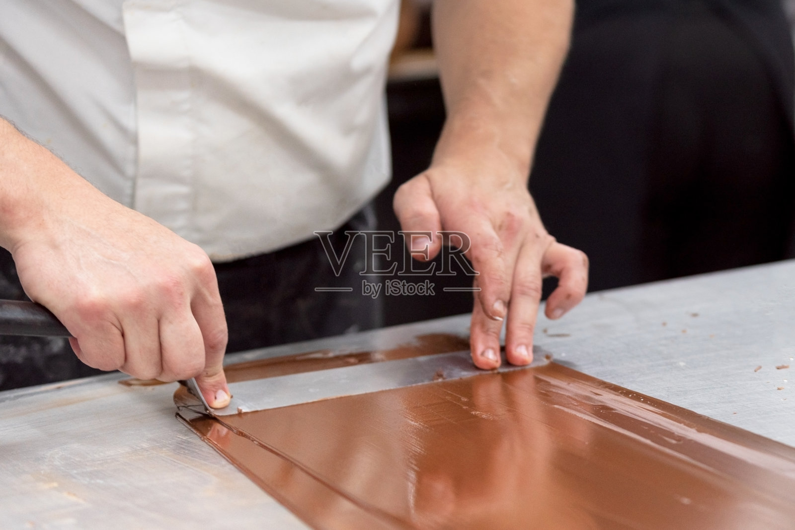 在糖果店制作巧克力糖果的专业糖果师。照片摄影图片