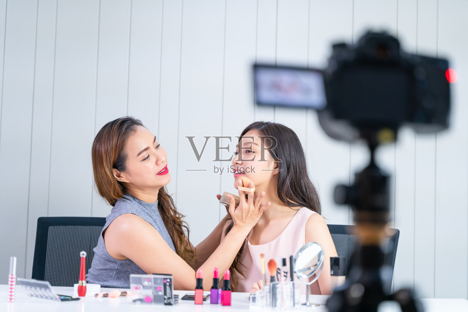 年轻女子视频博主在网上展示化妆教程。无线连接。照片摄影图片
