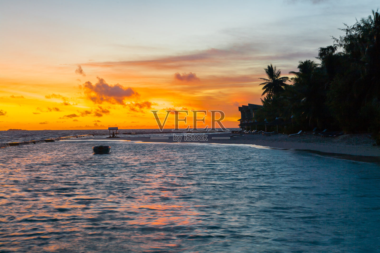 日落在马尔代夫Ellaidhoo岛，水上别墅度假胜地照片摄影图片