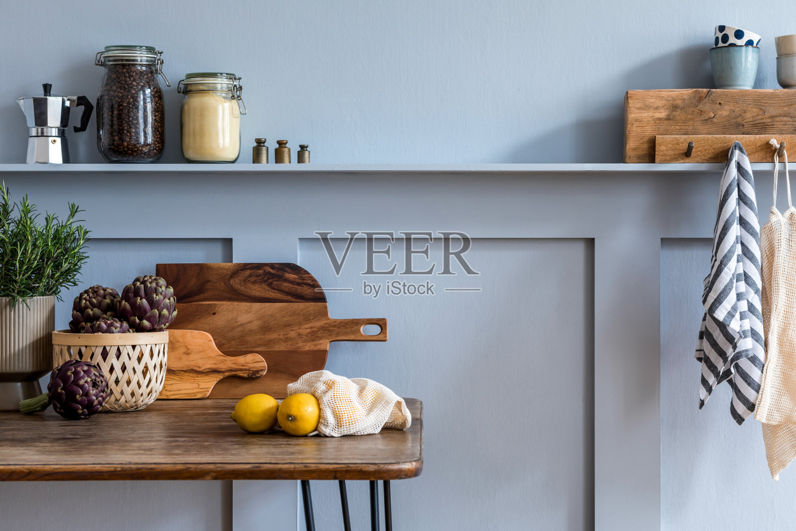 厨房内部以木制家庭餐桌、蔬菜、茶壶、甜点、植物和厨房配件为灰色概念的家居装饰。照片摄影图片