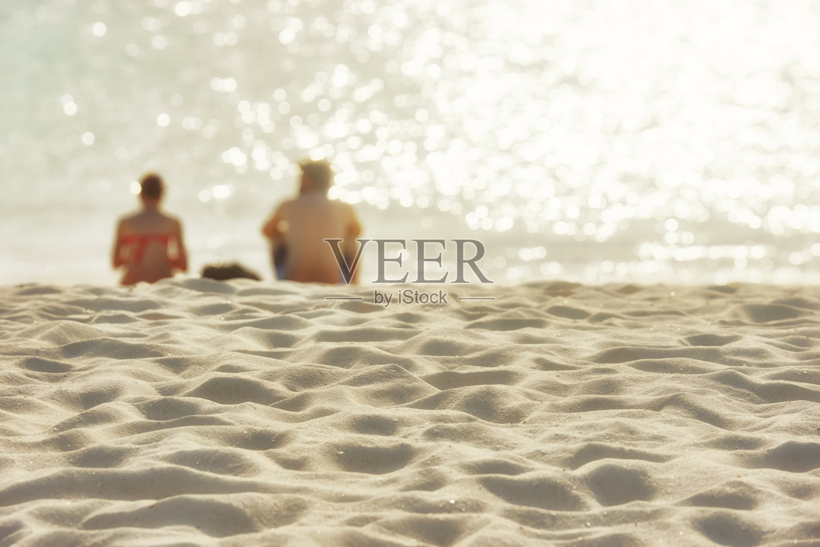 暑期概念-剪影的一个幸福的年轻夫妇与日落在海滩。照片摄影图片