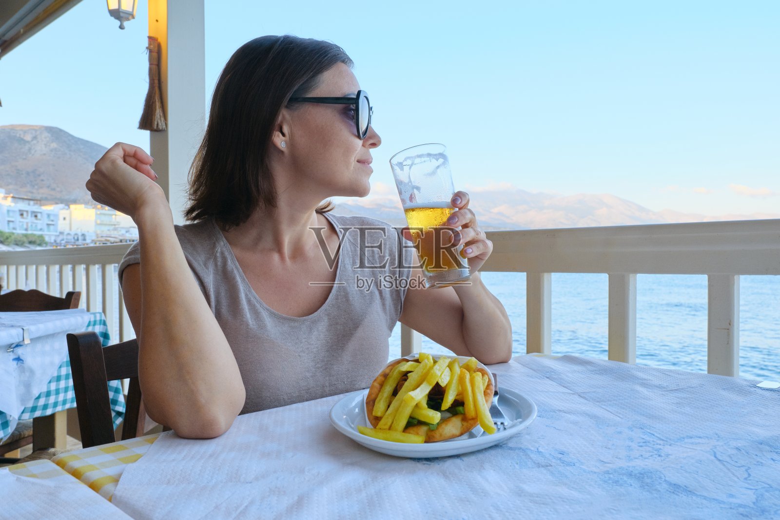 成熟美丽的女人在海边度假咖啡馆用餐照片摄影图片